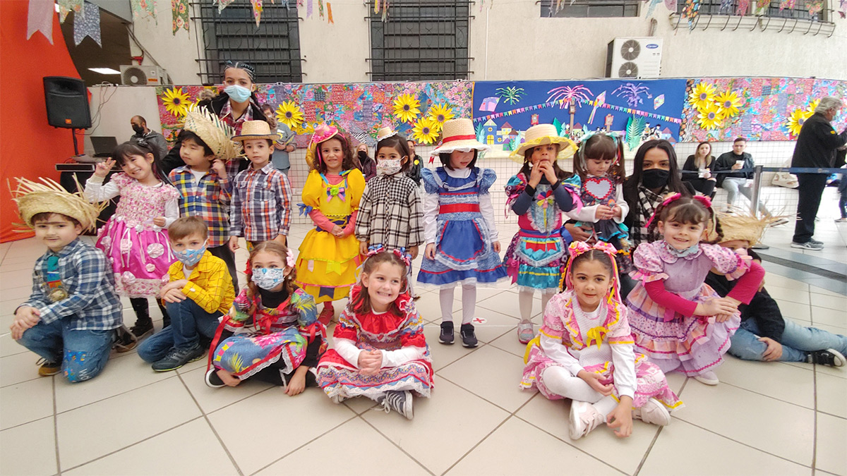 Foto de alunos vestidos com o tema junino posando para foto